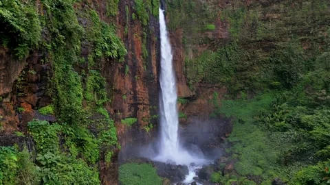 Kapas Biru Waterfall surrounded by lush tropical rainforest, East Java Indonesia 库存影片 346239507