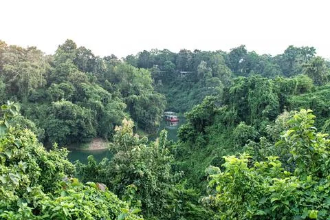 Kaptai Lake bordered by forest-covered hills Stock Photos