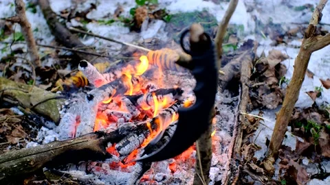 Karambit knife on the branch in front of bonfire in the dark snowy forest Video stock 167743513
