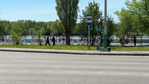Karate athletes of different ages, mostly children, run along the river Stock Footage 308584420