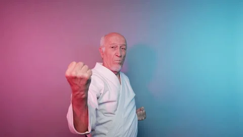 In karate, an elderly male athlete practices punches and blocks with his hands Stock Footage 340319209