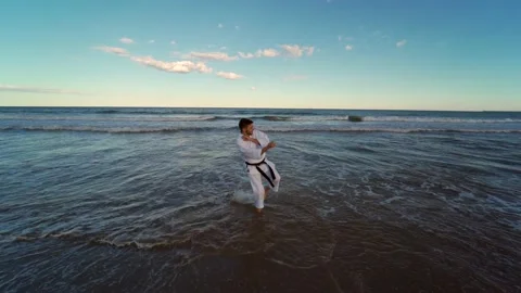 Karate fighter practicing katas on the seashore. Karate fighter practicing te Stock Footage 146604920