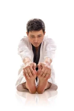 Karate guy in pike position, hamstring stretch, front view Stock Photos