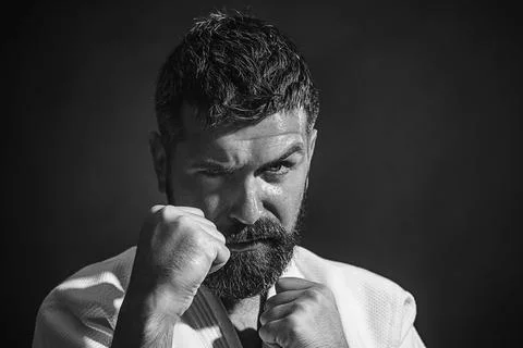 Karate man in fighting position. Bearded karate man in white kimono for sam.. Stock Photos