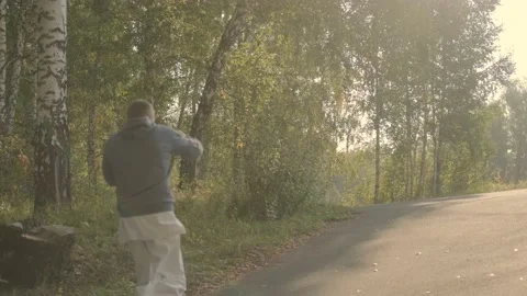Karate man. Jogging through the woods. Punches. Stock Footage 207859995