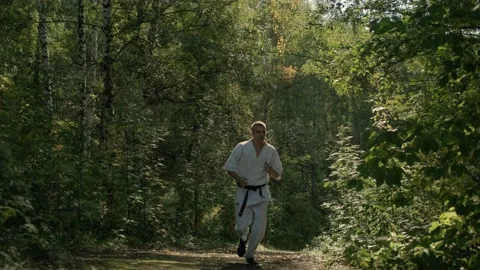 Karate man. Jogging through the woods. Stock Footage 207860096
