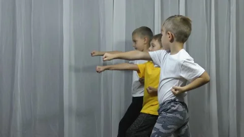 In a karate stance, three athletes practice punching Stock Footage 143196043