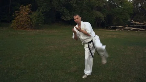 Karateka Guy Engaged in Kata Karate on the Glade in the City Park Morning Stock Footage 85449298