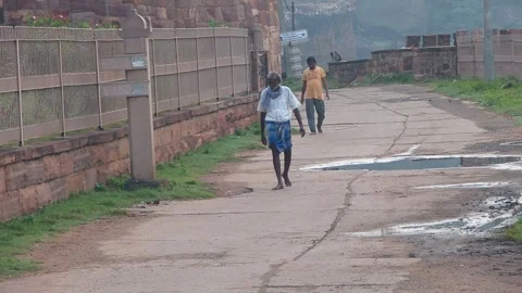 Karnataka- 04 Oct, 2024; Two Men Walking Barefoot on Temple Path in Badami caves Stock Footage 303561758