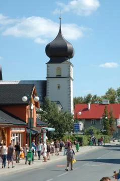 KARPACZ, POLAND - AUGUST 14: Unidentified people and church tower on main str Stock Photos