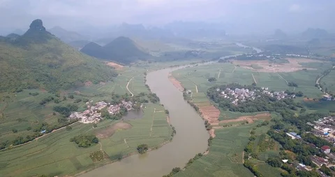 Karst formations and agricultural fields divided by a river in Guangxi provin Stock Footage 114637903