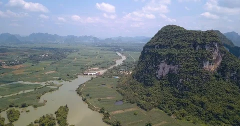 Karst formations and agricultural fields divided by a river in Guangxi provin Stock Footage 114653401