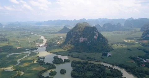Karst formations and agricultural fields divided by a river in Guangxi provin Stock Footage 114653545