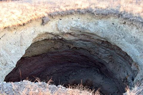 Karst funnel on the surface of the earth. Stock Photos