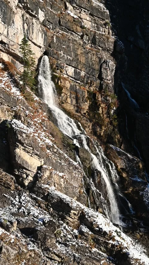 A karst spring in the middle of a wall in the mountains, evening sun in autumn Stock Footage 260873802