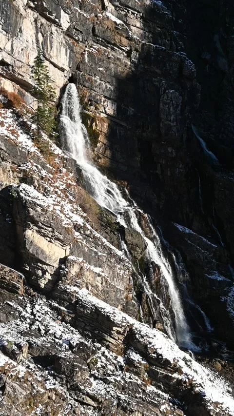 A karst spring in the middle of a wall in the mountains, evening sun in autumn Video stock 260873803