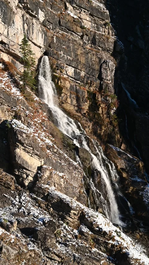 A karst spring in the middle of a wall in the mountains, evening sun in autumn Stock-Footage 260873817