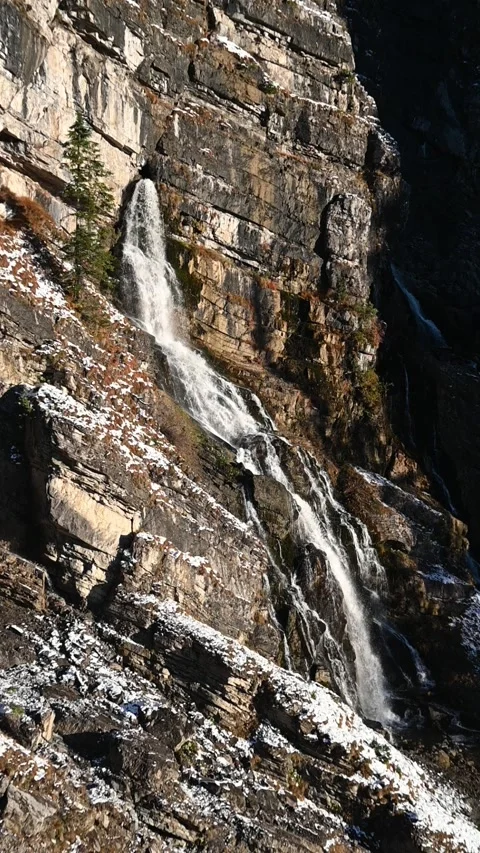 A karst spring in the middle of a wall in the mountains, evening sun in autumn Video stock 260873886