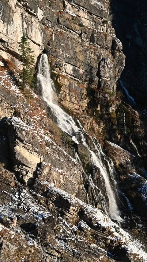 A karst spring in the middle of a wall in the mountains, evening sun in autumn Stock-Footage 260874046