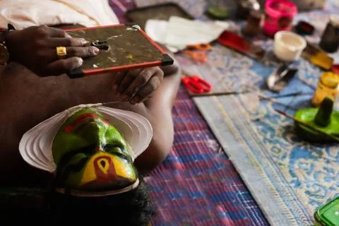 Katakhali dance performer doing face paint and makeup in front of hand held m Stock Photos
