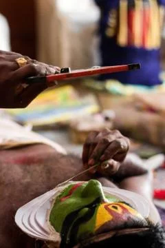 Katakhali dance performer doing face paint and makeup in front of hand held m Stock Photos