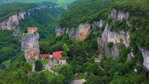 Katskhi Pillar dominates elevated aerial view above monastery roofs Stock Footage 340778034