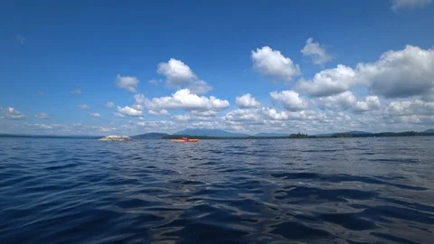 Kayak on Millinocket lake with fluflfy clouds and Katahdin in background Stock Footage 122740073