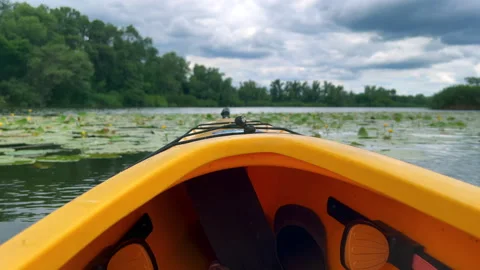Kayak moving on calm river under cloudy sky Stock Footage 312597971