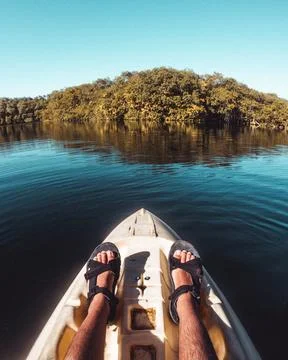 A kayak navigating a pond surrounded by forest Stock Photos