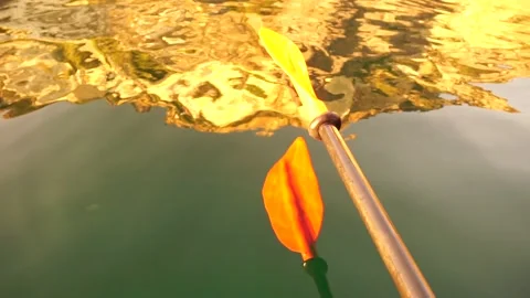 Kayak, paddle, sunset - Low angle view over clear azure sea water. Sun glare Stock Footage 267540214