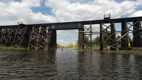 A Kayak Passing Under a Trestle Bridge Stock Footage 196019901