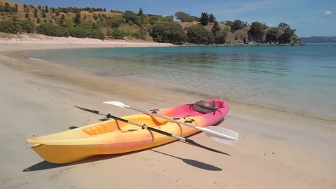 A kayak pulled up on the shoreline of a tropical beach Stock Footage 125114009