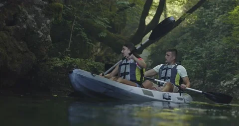 Kayak rowing slow motion. Kayaker woman and man kayaking in a beautiful Stock Footage 155263042