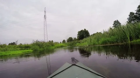 Kayak sailing on a narrow river. The flat terrain. The first-person. Stock Footage 79712744
