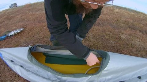 Kayaker assembles foldboat for kayaking under cloudy sky Stock Footage 124455899