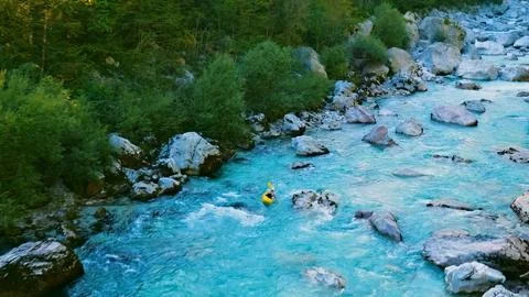 Kayaker conquers rapids, navigating through a rocky river Stock Photos