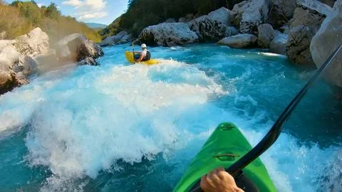 Kayaker conquers rapids, navigating through turbulent waters with skill and Stock Photos