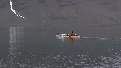 Kayaker in the middle of the Arctic Ocean front of Greenlandic mountains Stock Footage 103362392