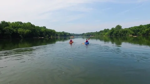 Kayakers paddling up the river Stock Footage 76944906