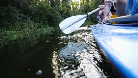 Kayaking action sequence showcasing rhythmic paddle strokes creating splashes Video stock 324753371