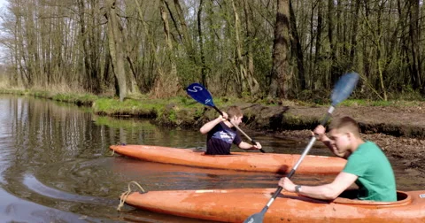 Kayaking active boys on river with kayaks close to camera Stock Footage 51451925