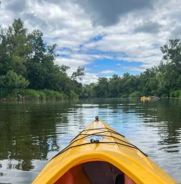 Kayaking on calm river under cloudy sky: exploring nature's beauty Stock Photos