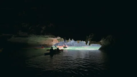 Kayaking Through a Dark Limestone Sea Cave into Bright Lagoon 動画素材 331195558