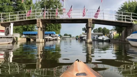 Kayaking under a bridge with American flags Stock Footage 160132447