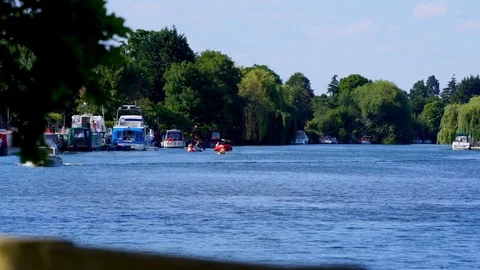 Kayaks and small boat float up river on sunny summers day Stock Footage 106772022