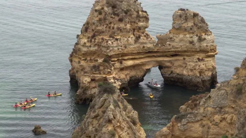 Kayaks in between rock formations on the sea coast of Lagos Portugal Stock Footage