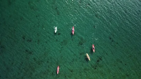 Kayaks of different colors float on the water in the ocean Stock Footage 252839081