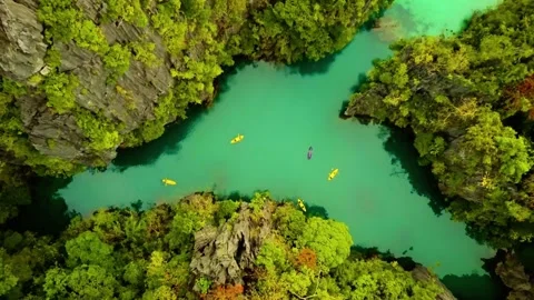 Kayaks float on a lagoon surrounded by cliffs 스톡 동영상 312483437