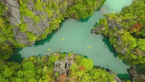 Kayaks float on turquoise water between rocky islands Stock Footage 312483043