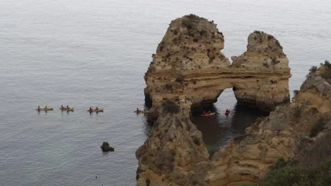 Kayaks slowly moving between rock formations on the sea coast of Lagos Portugal 動画素材 201369958